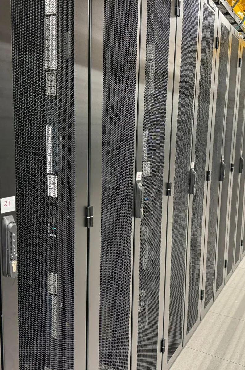 Colocation aisle with black cabinets and overhead containment